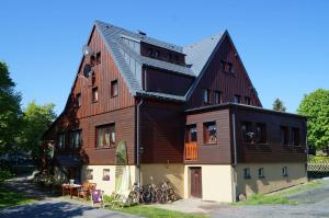 a large wooden house with bikes parked outside of it at Kammbaude Neuhermsdorf in Neuhermsdorf