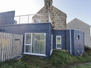 ein blaues Haus mit einem Kamin darüber in der Unterkunft Seaview at The Doocot in Elgin