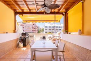 un tavolo e sedie su un balcone con ventilatore a soffitto di Design house 150m from Las Vistas Beach a Playa de las Americas