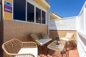 un patio con sedie e tavoli in vimini sul balcone. di Design house 150m from Las Vistas Beach a Playa de las Americas