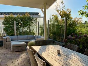 a patio with a couch and a table and chairs at WHITE BEACH HOUSE in Breskens