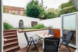 a patio with a table and chairs on a balcony at Gorgeous Kentish Town Flat in London