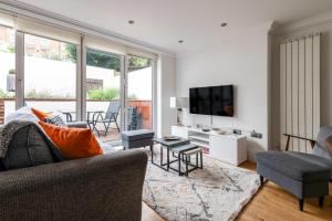 a living room with a couch and a tv at Gorgeous Kentish Town Flat in London