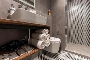 a bathroom with a toilet and a sink and towels at Apartments DREAM in Málaga +95 photos