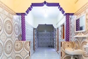 uma casa de banho com um lavatório e um espelho em aDAM em Dakhla