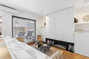 ein Wohnzimmer mit einem weißen Sofa und einem Tisch in der Unterkunft Julias Studio Stay in Knokke-Heist