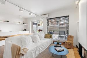 a living room with a white couch and a table at Julias Studio Stay in Knokke-Heist