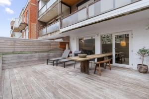 an outdoor patio with a wooden table and chairs at Julias Studio Stay in Knokke-Heist