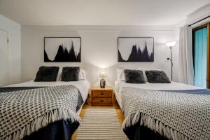 two beds sitting next to each other in a bedroom at Le SEVEN in Mont-Tremblant