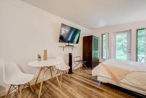 a white bedroom with a bed and a table and chairs at Le SEVEN in Mont-Tremblant