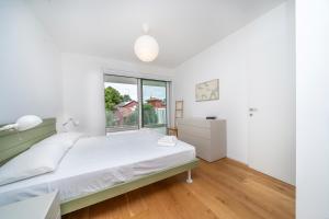 Habitación blanca con cama y ventana en Neos House, en Udine