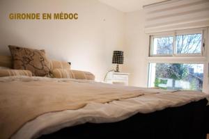 レスパール・メドックにあるBureau Lesparre-médoc, Les Pinsのベッドルーム(大型ベッド1台、窓付)