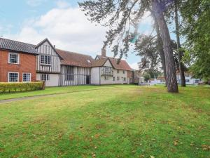 un gran patio frente a una casa con un árbol en 2 The Almshouses, en Saxmundham