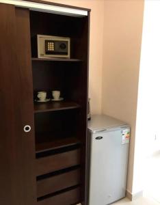 a kitchen with a microwave and a small refrigerator at Newen Bed and breakfast in El Chalten