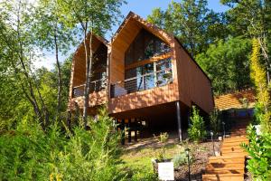 une maison moderne dans les bois avec des arbres dans l'établissement Parádka - Toscana Villa, à Parád