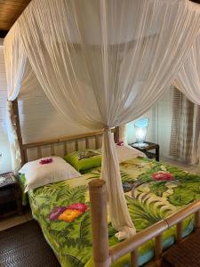 a bedroom with a bed with a canopy at Le Neem in Saint-François
