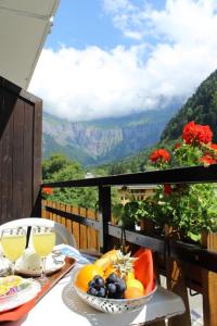 a table with a bowl of fruit on a balcony at Hôtel Le Choucas in Sixt