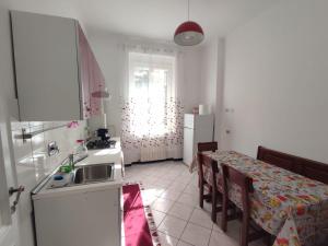 a kitchen with a table with chairs and a refrigerator at Lucia appartamento uso esclusivo - Aeroporto Genova Sestri Ponente in Genoa