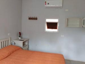 a bedroom with a bed and a window at Vila Juma in Camburi