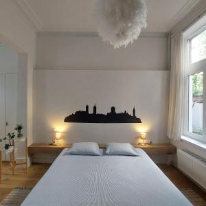 a bedroom with a large white bed and two lamps at Bennestay in Ghent