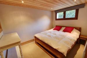 a bedroom with a bed with a desk and a window at Chalet Clara in Chamonix-Mont-Blanc