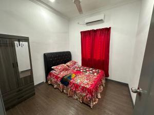 een slaapkamer met een bed en een rood gordijn bij Dhia Homestay2 in Macang