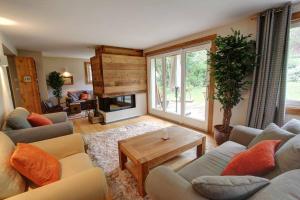 uma sala de estar com sofás, uma mesa e uma lareira em Chalet Clara em Chamonix-Mont-Blanc