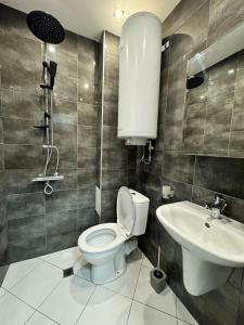 La salle de bains est pourvue de toilettes et d'un lavabo. dans l'établissement Central Studio Apartment - Varna City, à Varna