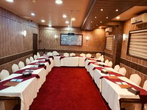a conference room with rows of tables and white chairs at Hotel Seever in Erbil