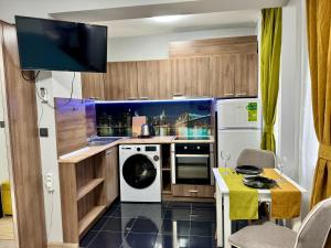 eine kleine Küche mit Waschmaschine und Trockner in der Unterkunft Central Studio Apartment - Varna City in Warna