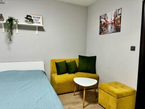 Zimmer mit einem Bett, einem gelben Sofa und einem Stuhl in der Unterkunft Central Studio Apartment - Varna City in Warna