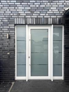 een dubbele deur op een bakstenen gebouw met aphalt bij Pension Imhof in Oyten
