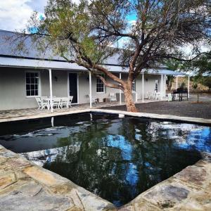 una piscina d'acqua di fronte a una casa di Grootfontein Farm House a Beaufort West