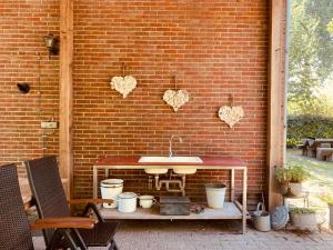 a patio with a sink and a brick wall at Logeren op de Thoolse Parel vakantiehuis in Stavenisse