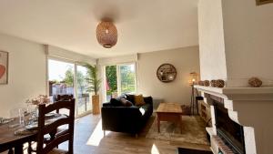 a living room with a couch and a fireplace at La Villa des Lilas in Saint-Valery-sur-Somme