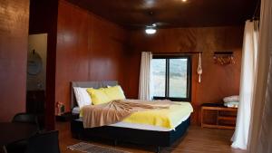1 dormitorio con cama y ventana en Famiglia da Serra, en Delfinópolis