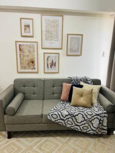 uma sala de estar com um sofá com almofadas em The Pink House em Davao