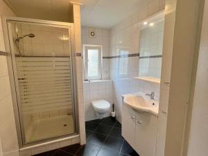 a bathroom with a shower and a toilet and a sink at WHITE BEACH HOUSE in Breskens +59 photos