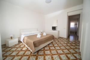 een witte slaapkamer met een bed en een televisie bij CAMA Casa Vacanze in Palermo