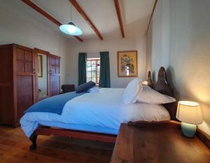 ein Schlafzimmer mit einem großen Bett und zwei Lampen in der Unterkunft Grootfontein Farm House in Beaufort West