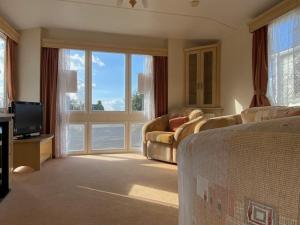 - un salon avec un canapé et une grande fenêtre dans l'établissement Coastal Caravan Holidays - Puffin 14, à Tunstall