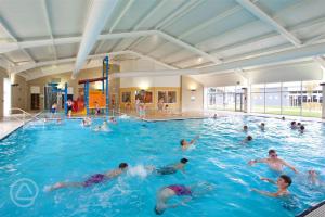 a group of people swimming in a swimming pool at Coastal Caravan Holidays - Puffin 14 in Tunstall