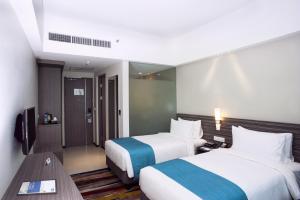 a hotel room with two beds and a table at Holiday Inn Express Surabaya CenterPoint, an IHG Hotel in Surabaya