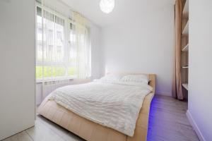 biała sypialnia z łóżkiem i oknem w obiekcie Apartamenty Zamkowe- High Standard Apartment w mieście Rzeszów