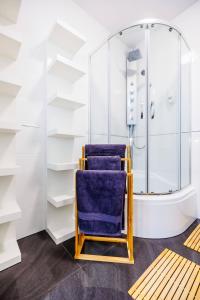 baño con ducha y silla azul en Apartamenty Zamkowe- High Standard Apartment, en Rzeszów