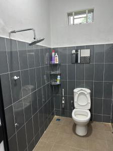 uma casa de banho com um WC e um chuveiro em Dhia Homestay2 em Macang