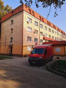 een rood busje geparkeerd voor een gebouw bij Studio apartments in center NEW 5 floor in Ivano-Frankivsʼk