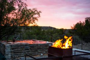 a man in a hot tub next to a fire pit at Grootfontein Farm House in Beaufort West