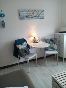 Habitación con mesa, 2 sillas y lámpara. en LE PETIT CABOURG de LA COUR NORMANDE Studio coeur de ville -1 à 2 personness, en Cabourg
