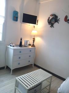 sypialnia z komodą i telewizorem na ścianie w obiekcie LE PETIT CABOURG de LA COUR NORMANDE Studio coeur de ville -1 à 2 personness w mieście Cabourg